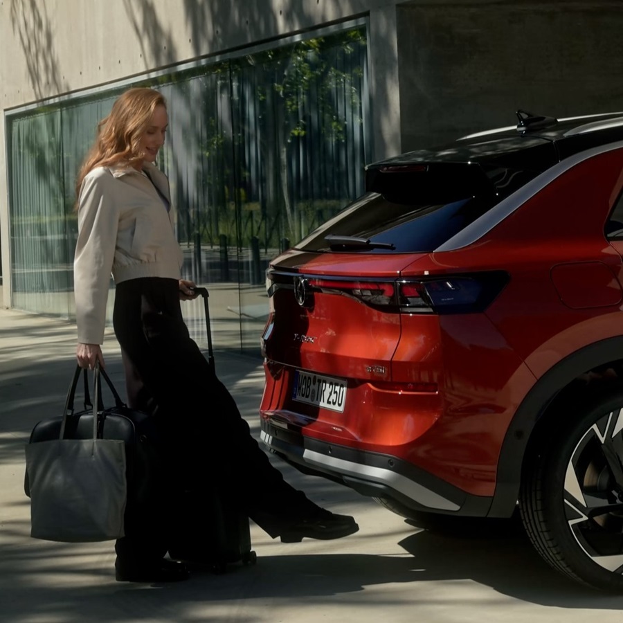 VW T-Roc in orange, Frau öffnet die Heckklappe