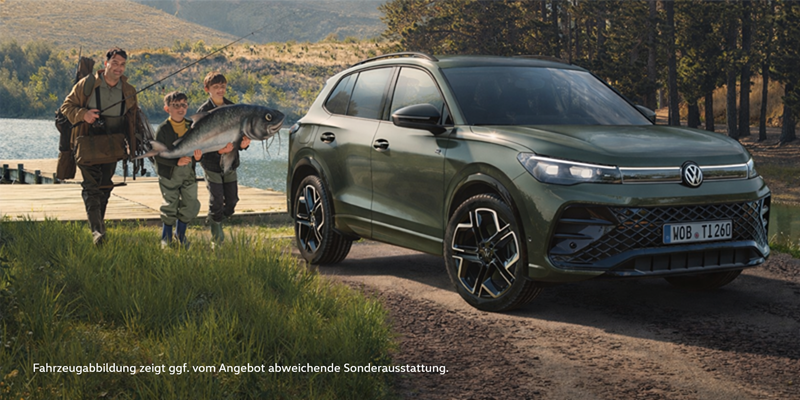 Der VW Tiguan in Grün an einem Waldsee mit drei Personen drauf